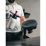 Person spraying water on a Mirka 9" Abralon J3 disc attached to a LEROS sander